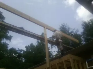 Carpenter setting a ridge beam over a new addition frame — Ice Dam Removal by Roofing Brothers in Napa