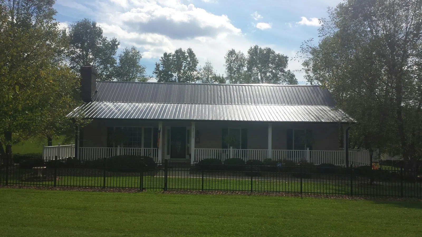 Gray metal roof on a brick ranch with a full width front porch — Gutter Guard Installation work by our crew in Napa